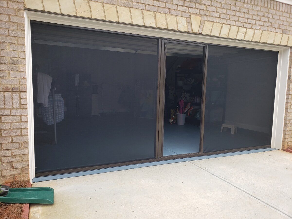 Lifestyle Screen Door installed on a tan stucco home garage entrance
